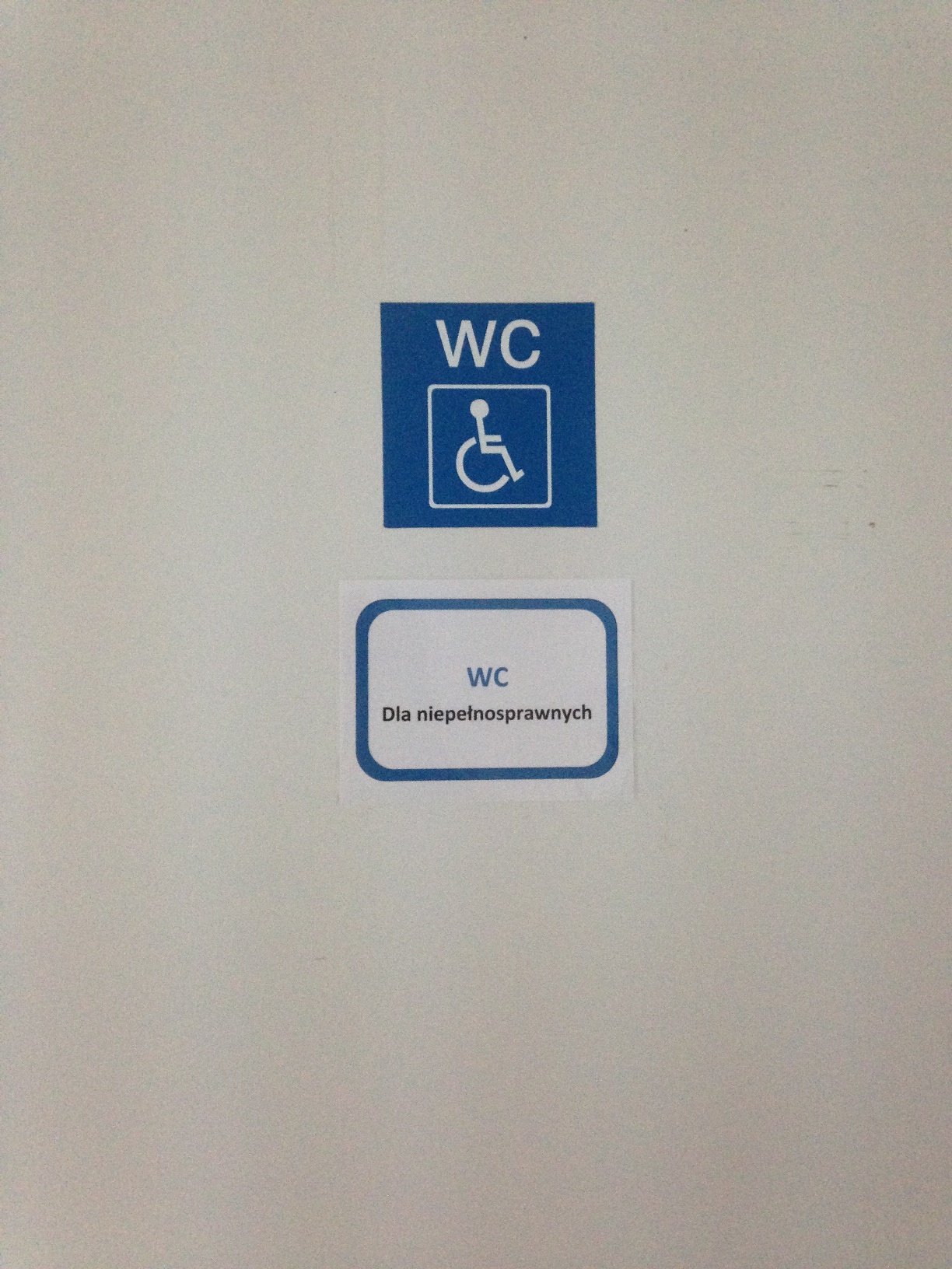 Oznaczenie na drzwiach prowadzących do toalety dla niepełnosprawnych na 2 piętrze.